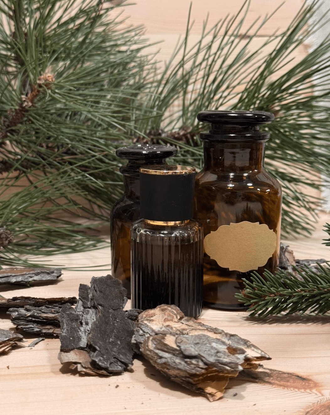 Natural perfume bottles with pine branches and bark